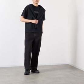 Model wearing Robyn Lynch Skint Logo T-Shirt in off black with black wide-leg trousers and black chunky shoes.