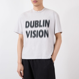 Model wearing Robyn Lynch grey cotton T-shirt with bold Dublin Vision graphic print, styled with black trousers.