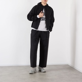 Model wearing Robyn Lynch grey cotton T-shirt, styled with black zip-up hoodie, black wide-leg trousers and grey trainers.