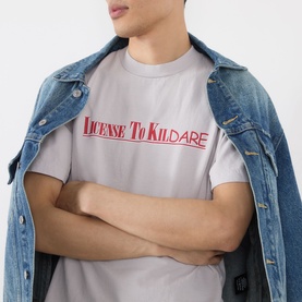 Model wearing Robyn Lynch grey cotton T-shirt with red "License To Kildare" slogan print, styled with a denim jacket
