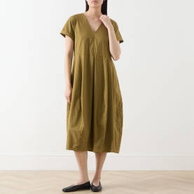 Model wearing Transit Pleated Pocket Dress in olive, V-neckline, short sleeves, midi length with pleated detail, styled with black flat shoes