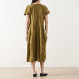 Model wearing Transit Pleated Pocket Dress in olive, midi length with short sleeves and pleated details, styled with black flat shoes