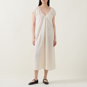 Model wearing Transit Textured Pocket Dress in sand, midi length, V-neckline, short sleeves, inverted front pleat, with black flat shoes