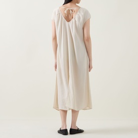 Model wearing Transit Textured Pocket Dress in sand, back view showing self-tie fastening at V-back, short sleeves, midi length