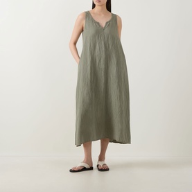 Model wearing Transit green sleeveless midi dress with V-neck and relaxed silhouette, styled with black flat sandals