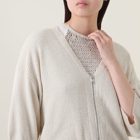 Model wearing Transit Zip Knit Cardigan in sand, V-neckline with two-way zip, styled over a white crochet top