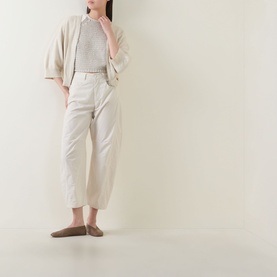 Model wearing Transit Zip Knit Cardigan in sand with three-quarter sleeves, styled with cream wide-leg trousers and taupe flats.