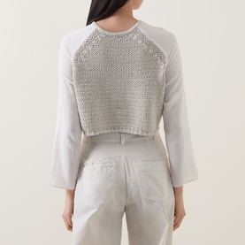 Model wearing Transit sand cropped knit top with open-stitch back panel and white raglan sleeves, styled with light grey trousers
