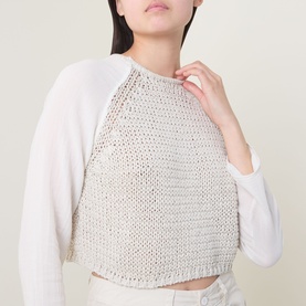 Model wearing Transit sand open-knit cotton crop top layered over white long-sleeve top, close-up detail view