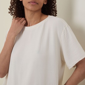 Model wearing Transit Textured Hybrid T-Shirt in Sand, round neckline, short sleeves, shadow stripe texture, close-up detail shot
