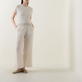 Model wearing Transit white/sand ribbed cotton-linen knit top with wide-leg trousers and tan loafers