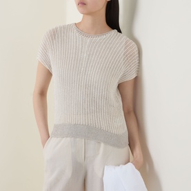 Model wearing Transit knit top in white and sand, ribbed texture with contrast hem, paired with cream wide-leg trousers
