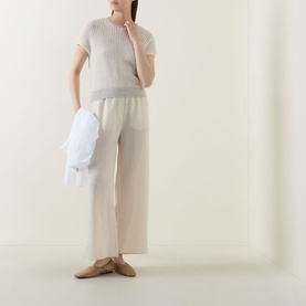 Model wearing Transit white/sand ribbed cotton-linen knit top with wide-leg cream trousers and tan loafers, holding white jacket