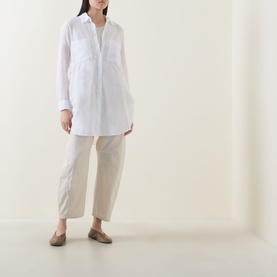 Model wearing Transit Patch Pocket Shirt in white with pointed collar and chest pockets, styled with stone linen trousers and tan loafers.