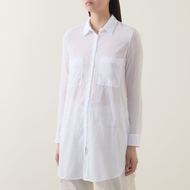 Model wearing Transit Patch Pocket Shirt in white, semi-sheer cotton with pointed collar, chest patch pockets and curved hem.