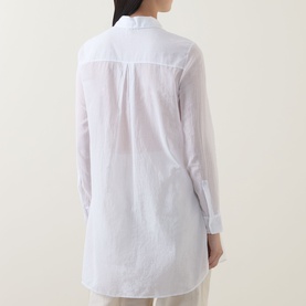 Model wearing Transit Patch Pocket Shirt in white, rear view showing relaxed longline fit, button fastening and curved hemline
