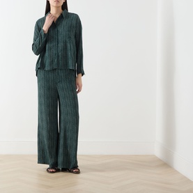 Model wearing Transit Stripe Pocket Shirt in petrol, styled with matching wide-leg striped trousers and black sandals