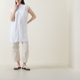 Model wearing Transit Patch Pocket Blouse in white with standing collar, cap sleeves and longline hem, styled with beige trousers and dark sandals