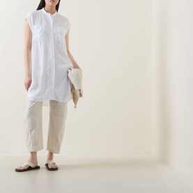 Model wearing Transit Patch Pocket Blouse in white with standing collar, cap sleeves, and longline fit, styled with beige cropped trousers and