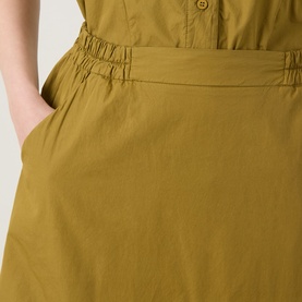 Model wearing Transit olive cotton skirt, close-up showing elasticated waistband and side pocket detail