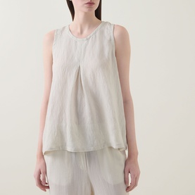 Model wearing Transit Pleated Textured Blouse in sand, sleeveless with inverted front pleat and round neckline, styled with matching wide-leg