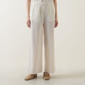 Model wearing Transit sand wide-leg trousers with elasticated waist and patch pocket, styled with beige flat shoes
