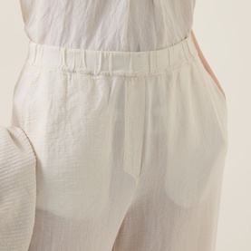 Model wearing Transit sand trousers with elasticated waistband, relaxed wide-leg fit in cotton-lyocell-viscose blend