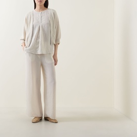 Model wearing Transit sand wide-leg trousers in cotton-lyocell-viscose blend, styled with a light linen blouse and nude ballet flats.