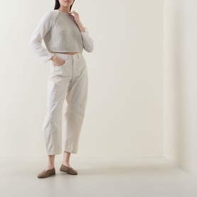 Model wearing Transit Cropped Barrel Leg Trousers in sand linen, styled with a cropped knit top and taupe mules.