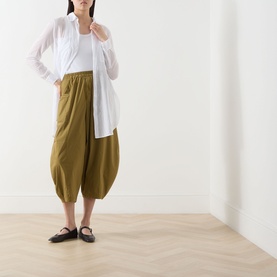 Model wearing Transit Bombe&egrave; Cropped Trousers in olive with elasticated waist and balloon silhouette, styled with white shirt and black flats.