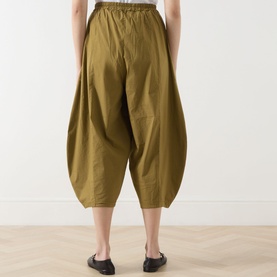 Model wearing Transit Bombe&egrave; Cropped Trousers in olive, rear view showing balloon-shaped silhouette and elasticated waistband, styled with black