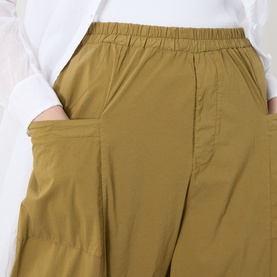 Model wearing Transit Bombe&egrave; Cropped Trousers in olive, showing elasticated waistband and front patch pockets, styled with white top.