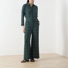 Model wearing Transit Stripe Wide Leg Trousers in petrol, styled with a matching striped shirt and brown flat sandals.