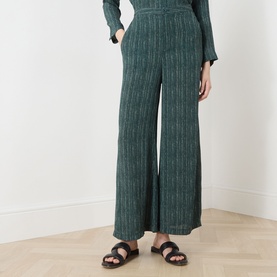 Model wearing Transit Stripe Wide Leg Trousers in petrol, wide-cut silhouette with stripe pattern, styled with black sandals