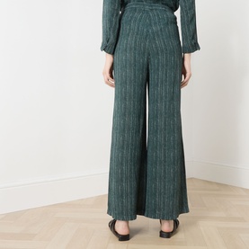 Model wearing Transit Stripe Wide Leg Trousers in petrol, wide-cut silhouette with vertical stripe pattern, styled with matching top and black flats.