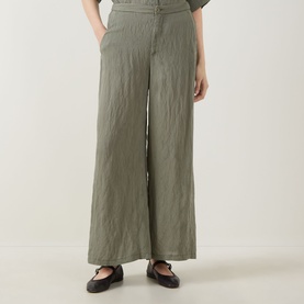 Model wearing Transit Textured Wide Leg Trousers in green, wide-leg silhouette in crinkled fabric, styled with black ballet flats.
