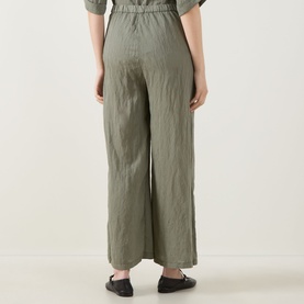 Model wearing Transit Textured Wide Leg Trousers in green, wide-leg silhouette, textured fabric, paired with black flat shoes.