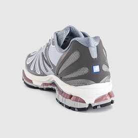 New Balance trainer in dark silver metallic grey, rear view showing mesh upper, chunky multicolour sole with pink and black detailing, small blue