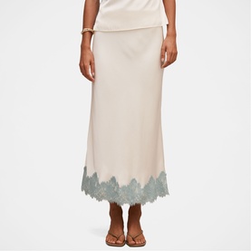 Model wearing Forever New champagne midi skirt with teal lace hem trim, styled with a matching top and strappy sandals.