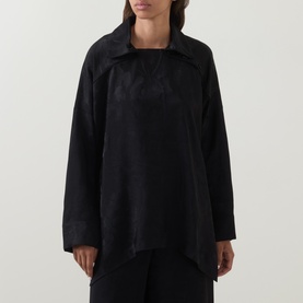 Model wearing Annette Gortz black viscose blouse with wide collar, long sleeves and relaxed silhouette, styled with black trousers.