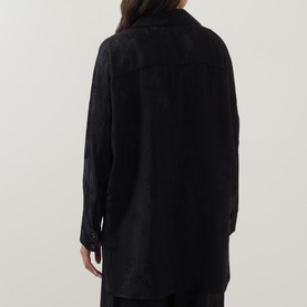Model wearing Annette Gortz black viscose blouse, rear view showing relaxed oversized fit and long sleeves