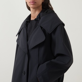 Model wearing Annette Gortz black cotton jacket with wide lapels and oversized silhouette, close-up detail view.