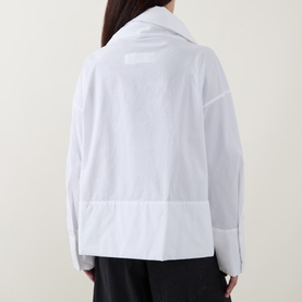 Model wearing Annette Gortz white cotton shirt, rear view showing relaxed fit, oversized collar and curved hem detail.