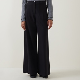 Model wearing Annette Gortz black wide-leg cotton trousers with high waist, styled with a grey long-sleeve top.