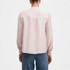 Model wearing Forever New blush pink long-sleeve blouse with button cuff detail, back view, styled with blue jeans.