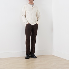 Model wearing Citizens of Humanity Straight Jeans in Tobacco, styled with a cream henley top and black shoes.