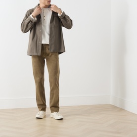 Model wearing Citizens of Humanity dark khaki straight jeans, styled with an olive overshirt and white trainers.
