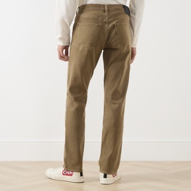 Model wearing Citizens of Humanity dark khaki straight jeans, rear view, styled with a white top and white trainers.