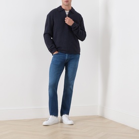 Model wearing Citizens of Humanity Gage Slim Leg Jeans in Watson mid wash, styled with a navy polo sweatshirt and white trainers.
