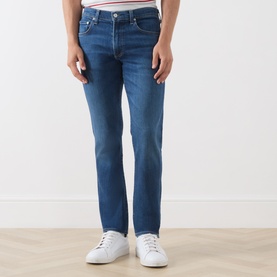 Model wearing Citizens of Humanity Gage Slim Leg Jeans in Watson mid wash, styled with white trainers and a striped shirt.